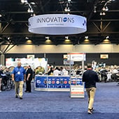 Show floor with large ring hanging from the ceiling with the Innovations logo
