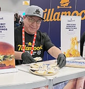 Exhibitor serving food behind counter at a trade show booth